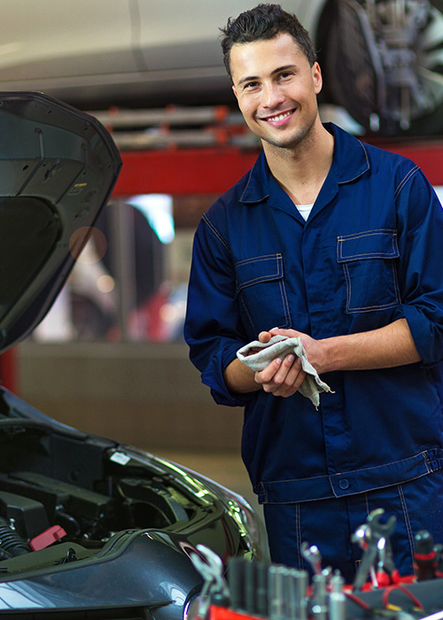 mechanic wiping his hands and smiling at the camera